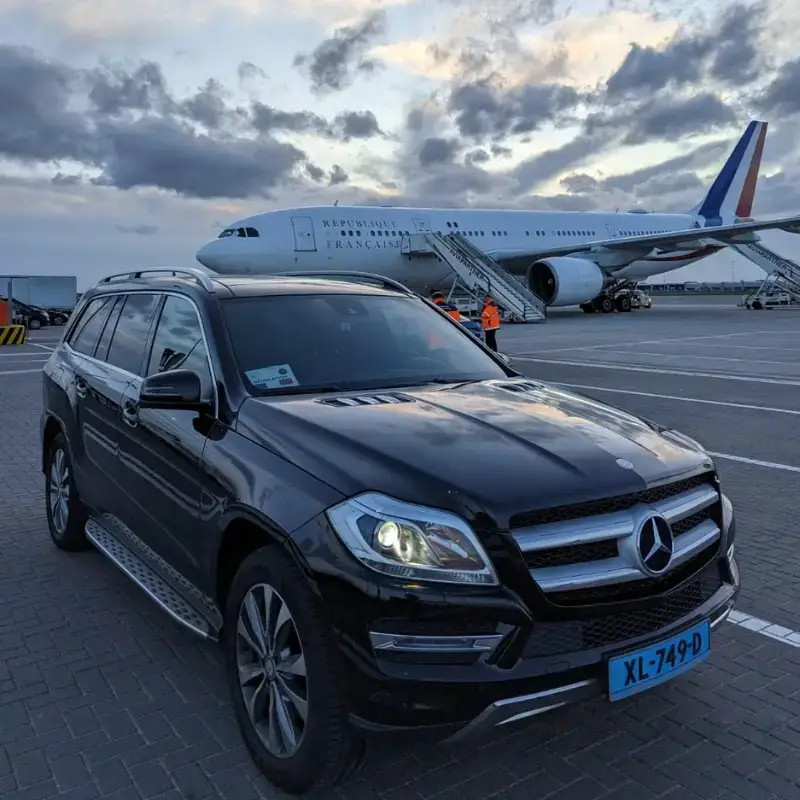 "Mercedes taxi van Regio Taxi Spijkenisse naast vliegtuig voor luchthavenvervoer naar Schiphol of Rotterdam Airport"