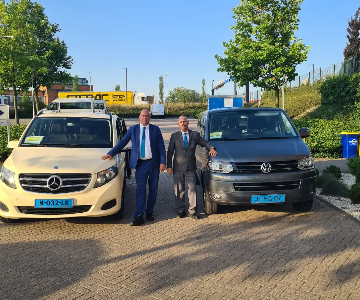 Two professional taxi drivers ready for crew transport and airport transfers in Rotterdam and surrounding area